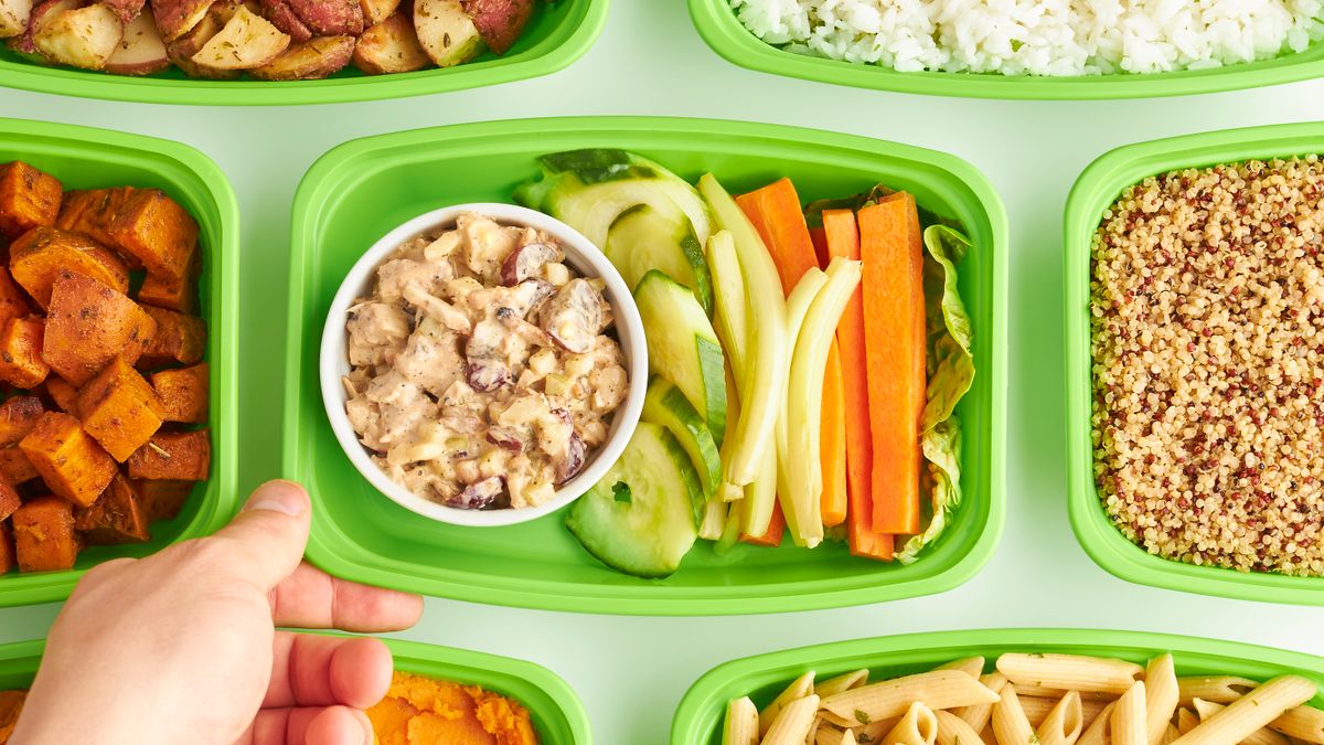 Overhead view of meal prep containers with vegetables, rice, quinoa and pasta